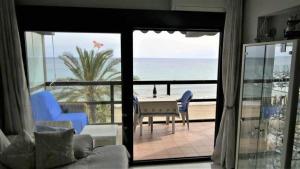 a living room with a table and chairs and a view of the ocean at Calpemar Vistas panorámicas a la playa 4º piso in Calpe