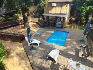 uma vista sobre um pátio com uma piscina e guarda-sóis em Goodnight Guest Lodge em Joanesburgo