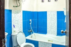 een blauwe badkamer met een toilet en een bad bij Samar Wulu Guest House Syariah Mitra RedDoorz near Ketapang in Ketapang
