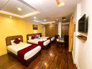 a hotel room with two beds and a flat screen tv at Thamel Grand Hotel in Kathmandu