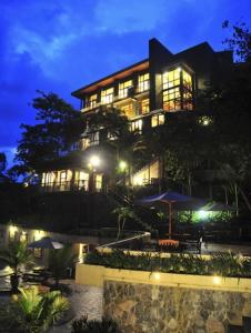 un gran edificio con una sombrilla delante de él en SanGria Resort And Spa, en Lembang