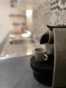une tasse de café assise sur un support sur un comptoir dans l'établissement T2 Hyper centre 3 étoiles Rue des Bains, à Aix-les-Bains