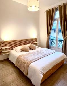 - une chambre avec un grand lit et une fenêtre dans l'établissement T2 Hyper centre 3 étoiles Rue des Bains, à Aix-les-Bains