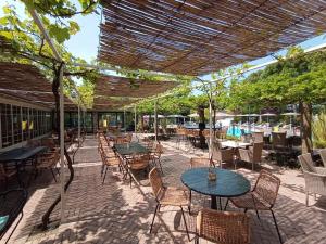 an outdoor patio with tables and chairs and an umbrella at Park Residence Il Gabbiano in Moniga