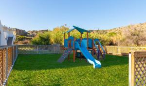 a playground with a slide in a yard at Blue Sea Beach Resort in Faliraki