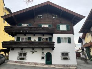 a large white house with a wooden roof at Koller, Pension Haus in Kitzbühel