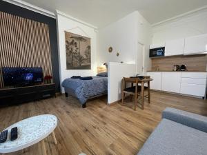 Una sala de estar con una cama y una cocina. en L'Escale Studio Arras avec parking privé, en Arras