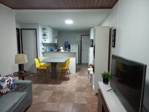 sala de estar y cocina con mesa y sillas amarillas en FLAT 107 VILLA HÍPICA Gravatá PE, en Gravatá