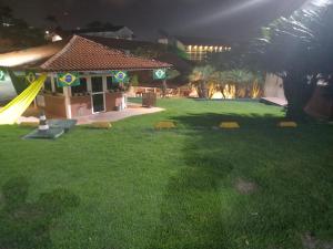 un patio trasero por la noche con un parque infantil y un tobogán en FLAT 107 VILLA HÍPICA Gravatá PE, en Gravatá