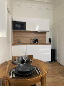 a kitchen with a wooden table with a plate on it at L'Escale Studio Arras avec parking privé in Arras