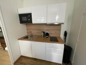a small kitchen with a sink and a microwave at L'Escale Studio Arras avec parking privé in Arras