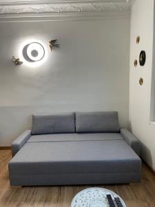 a gray couch in a room with a ceiling at L'Escale Studio Arras avec parking privé in Arras