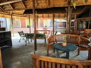 um restaurante com mesas e cadeiras de madeira e uma mesa em Goodnight Guest Lodge em Joanesburgo