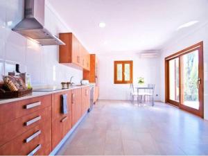 a large kitchen with wooden cabinets and a table at Finca Santa María in Alcudia