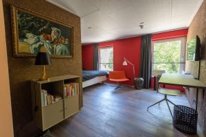 Habitación con cama y escritorio con mesa. en Hotel Leeuwerik en Bad-Nieuweschans