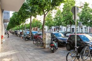 a row of parked bikes and cars on a city street at DR Apartments Friedrichshain in Berlin