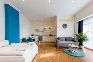 un soggiorno con divano bianco e parete blu di DR Apartments Friedrichshain a Berlino