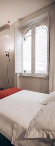 a bedroom with a white bed and a window at Casa 3D'Oro Palermo in Palermo