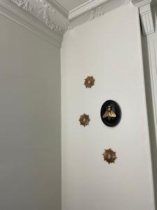 a room with a white wall with three clocks on the wall at L'Escale Studio Arras avec parking privé in Arras