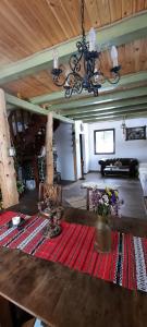 - un salon avec un lustre et un tapis rouge dans l'établissement Baladă de Rarău, à Câmpulung Moldovenesc