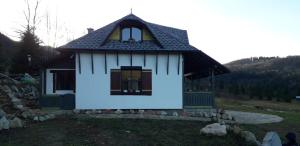 Una pequeña casa con un cartel azul en el costado. en Baladă de Rarău, en Câmpulung Moldovenesc
