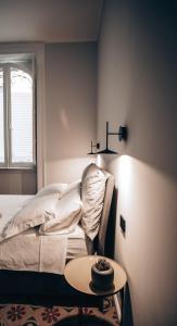 a bedroom with a bed and a table and a window at Casa 3D'Oro Palermo in Palermo