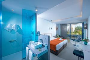 ein Hotelzimmer mit einem Bett und einem Bad in der Unterkunft Harmony Boutique Resort - Adults oriented in Georgioupoli