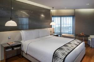 a bedroom with a large white bed and a table at The Park Hyderabad, Banjara Hills near Hussain Sagar Lake in Hyderabad