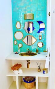 ein Badezimmer mit einem Waschbecken und einer blau gefliesten Wand in der Unterkunft Qasabah Majorelle in Saint-Gilles-les-Bains