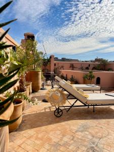 eine Terrasse mit einem Sofa und einem Surfbrett darauf in der Unterkunft Riad Dar Foundouk and Spa in Marrakesch