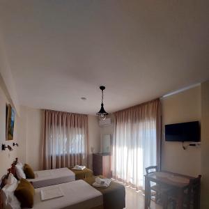 a living room with two white couches and a table at Estia Vasilis Manoli in Ayia Napa