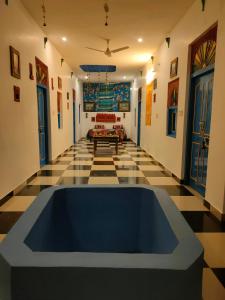 um quarto com uma banheira azul no meio de um piso em Bhavyam Heritage Guest House em Jodhpur