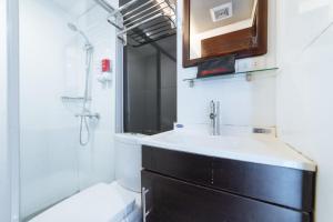 a bathroom with a sink and a mirror and a shower at RedDoorz Plus at One Liberty Hotel Kalayaan Avenue in Manila