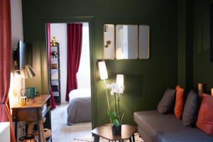 salon z zielonymi ścianami i kanapą w obiekcie Les Gites By Carpe Diem w mieście Les Andelys