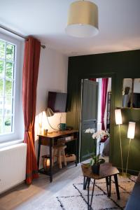 ein Wohnzimmer mit einem Schreibtisch und einem Spiegel in der Unterkunft Les Gites By Carpe Diem in Les Andelys