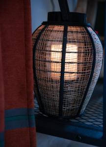 eine Korblampe auf einem Bett in der Unterkunft Les Gites By Carpe Diem in Les Andelys