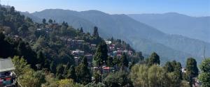 una città su una collina con montagne sullo sfondo di Ridge View Chalet Homestay a Darjeeling