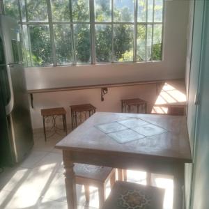 a table and chairs in a room with a window at Recanto Bela Vista serra in Tiradentes