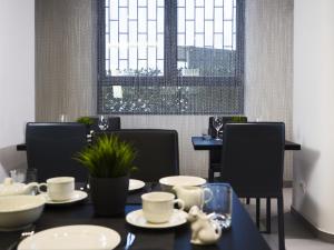 uma sala de jantar com uma mesa e cadeiras e uma janela em Loto Business Hotel em Roma