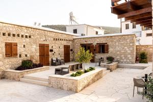 a patio with tables and chairs in front of a stone building at Harma Traditional Boutique Suites in Paphos City