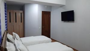 a room with two beds and a flat screen tv at Solim in Khorog