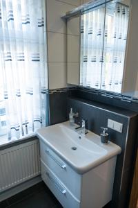 a bathroom with a white sink and a mirror at Zur Krone Leimen in Leimen