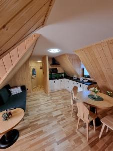 a living room with a table and a kitchen at Apartament GRA-AND in Maruszyna