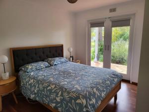 a bedroom with a bed with a blue comforter at 90 Mile Beach Escape in Seaspray