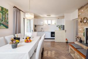 een keuken en eetkamer met een witte tafel en stoelen bij Villa Marko in Stanići