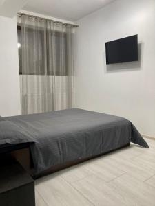 a bedroom with a bed and a flat screen tv at Apartament Luca in Drobeta-Turnu Severin