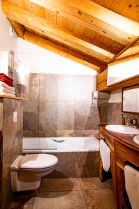 een badkamer met een bad, een toilet en een wastafel bij Les Deux Tetes 2 Chez Fifine in Arc 1600