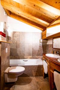 a bathroom with a tub and a toilet and a sink at Les Deux Tetes 2 Chez Fifine in Arc 1600