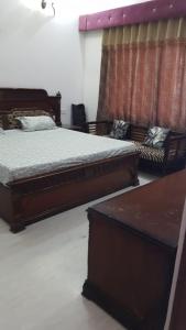 Un dormitorio con 2 camas y un banco. en Kailash Haveli, en Bikaner