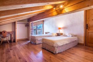 two beds in a room with wooden floors and ceilings at Les Deux Tetes 2 Chez Fifine in Arc 1600